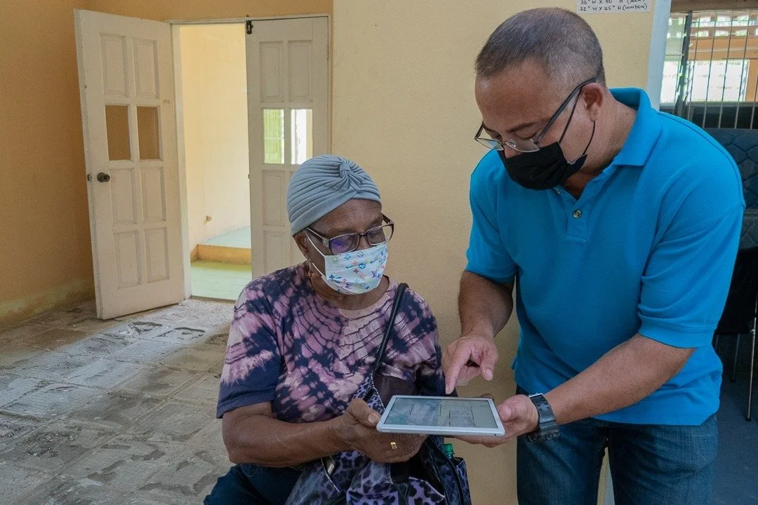 One of the contractors, Russel Aching (right) explains an architectural layout to Mizpeh Halfway House Founder, Reverend Pearl Noreiga (left)
