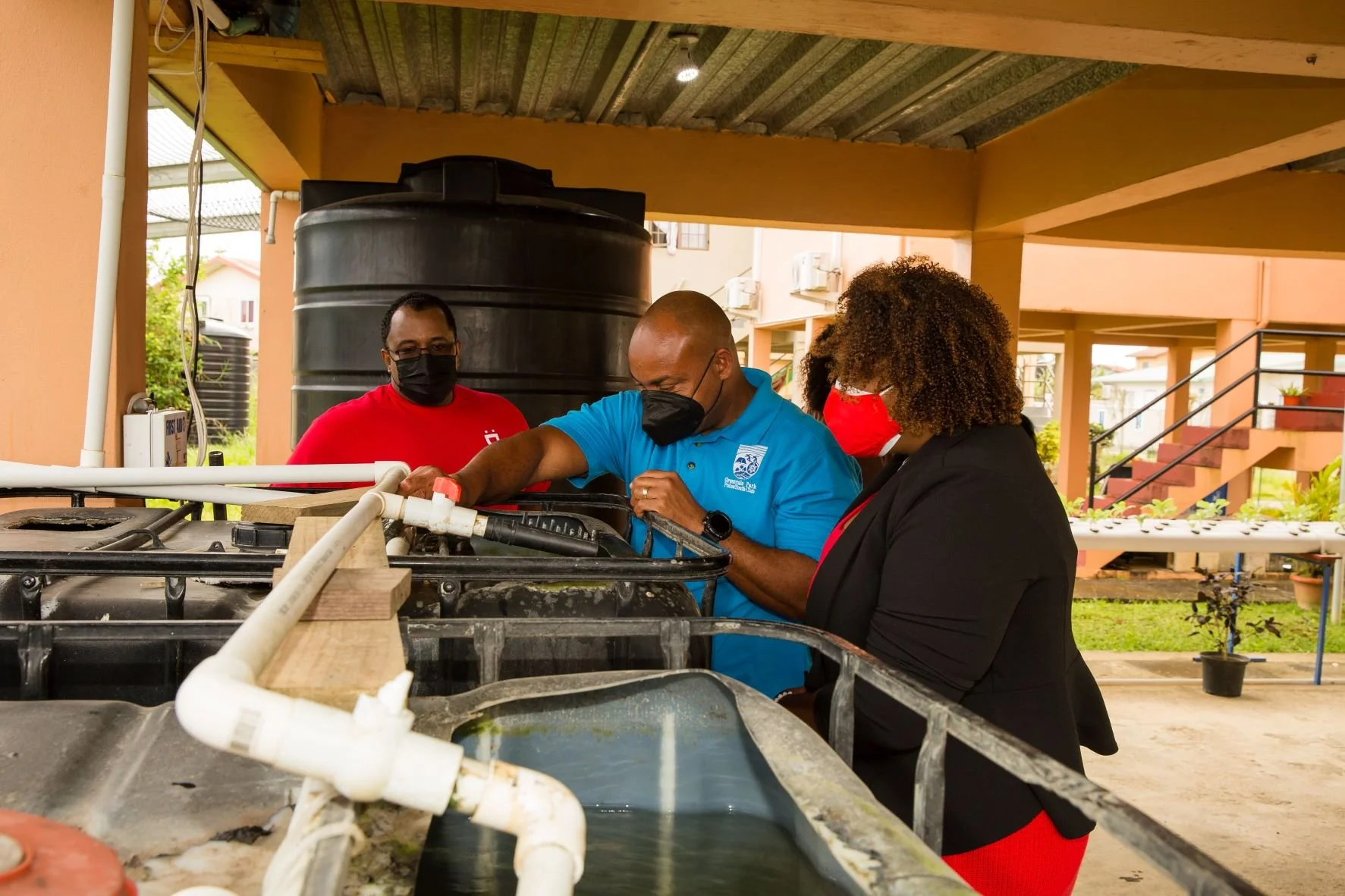 Norman Sorzano - Greenvale Park Police Youth Club President (centre) explains the operation of the system to Digicel Senior VAS and billing Enginee, Mr. John Ramirez (left) and Digicel Foundation Director, La Toya Gopaul.