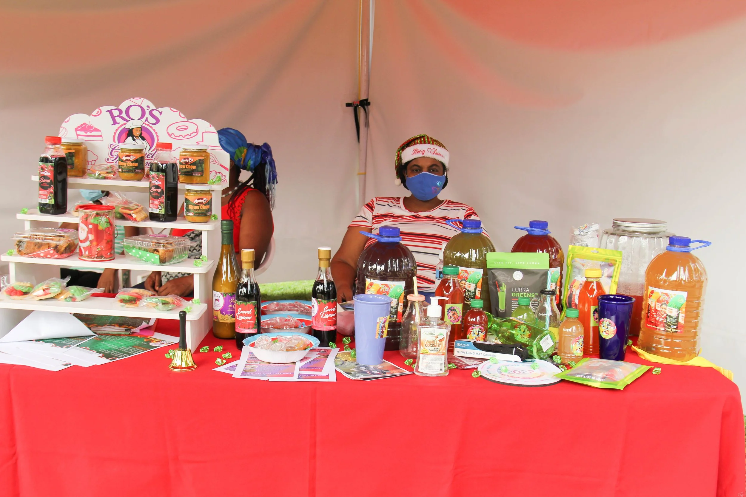 A female vendor displays her delicious selection of staple Trini Christmas items such as sorrel and chow chow.