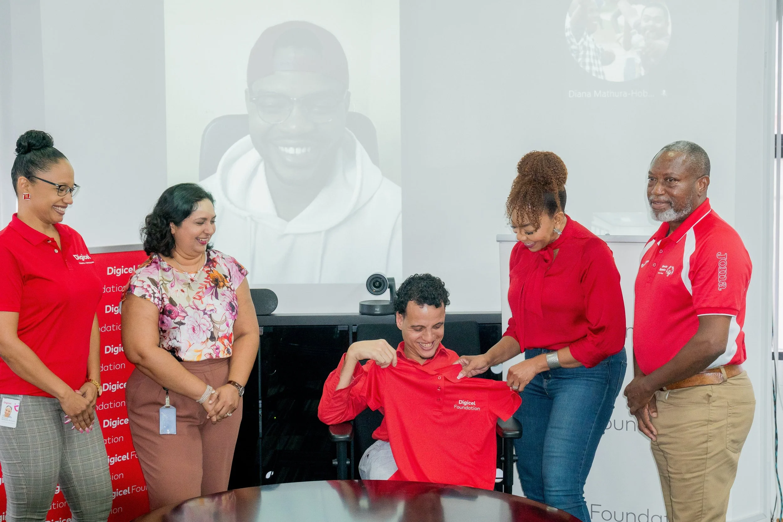 Joe Brien and Kevin Soyer receive a warm welcome as the selected endorsees of the Special Olympic National Games of T&T. L-R: Digicel Foundation Directors Romona Boisselle-Romano and Trijata Maraj; Kevin Soyer (on screen); Joe Brien; Digicel Foundation CEO Penny Gomez, and Special Olympics Trinidad and Tobago National Director Ferdinand Bibby.