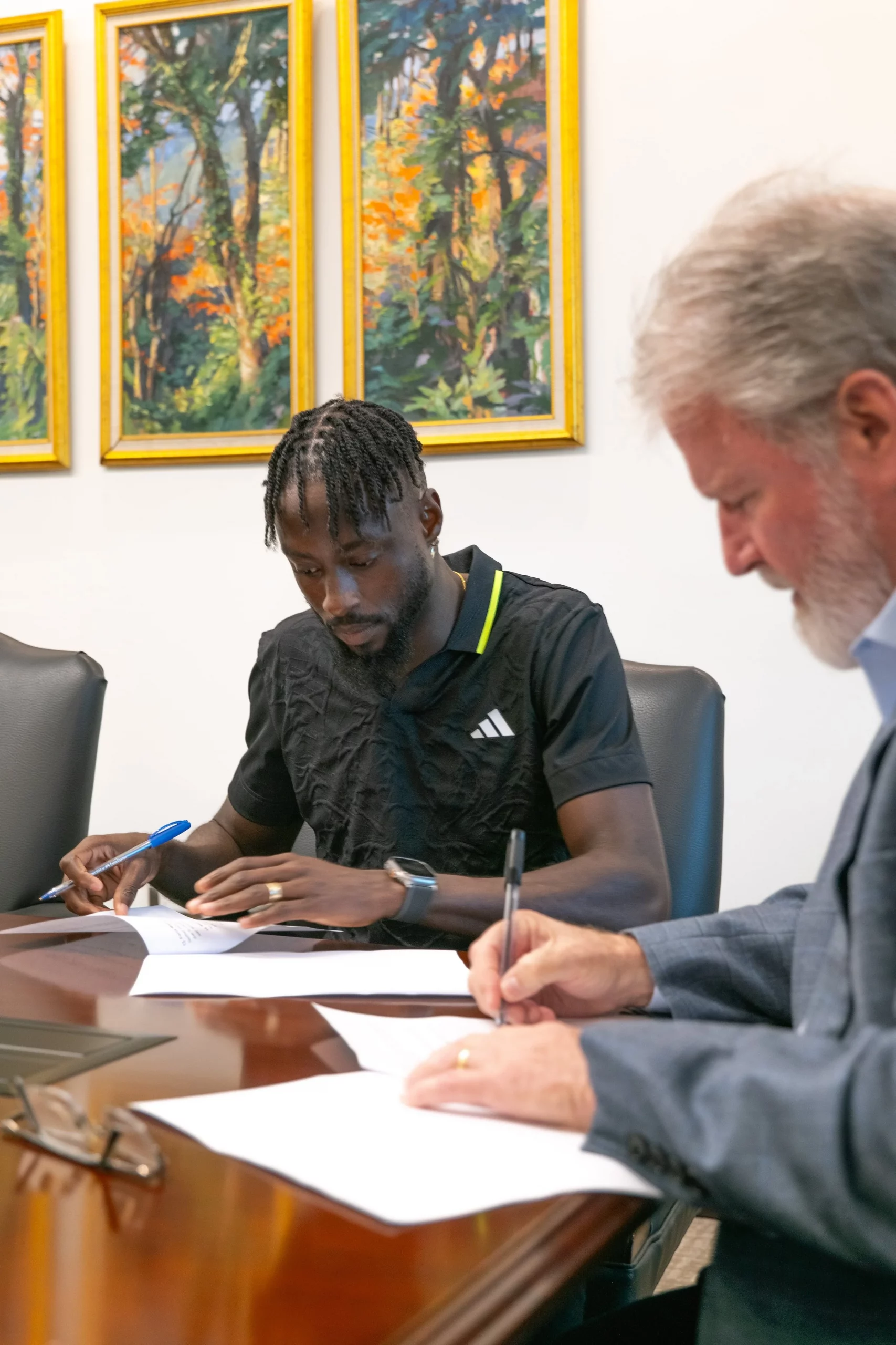 Michael Conyers, Deputy Chairman of the Brydens Group, signs a Sponsorship/Corporate Brand Ambassador Agreement with T&T Olympian Jereem Richards on 20 June 2024.