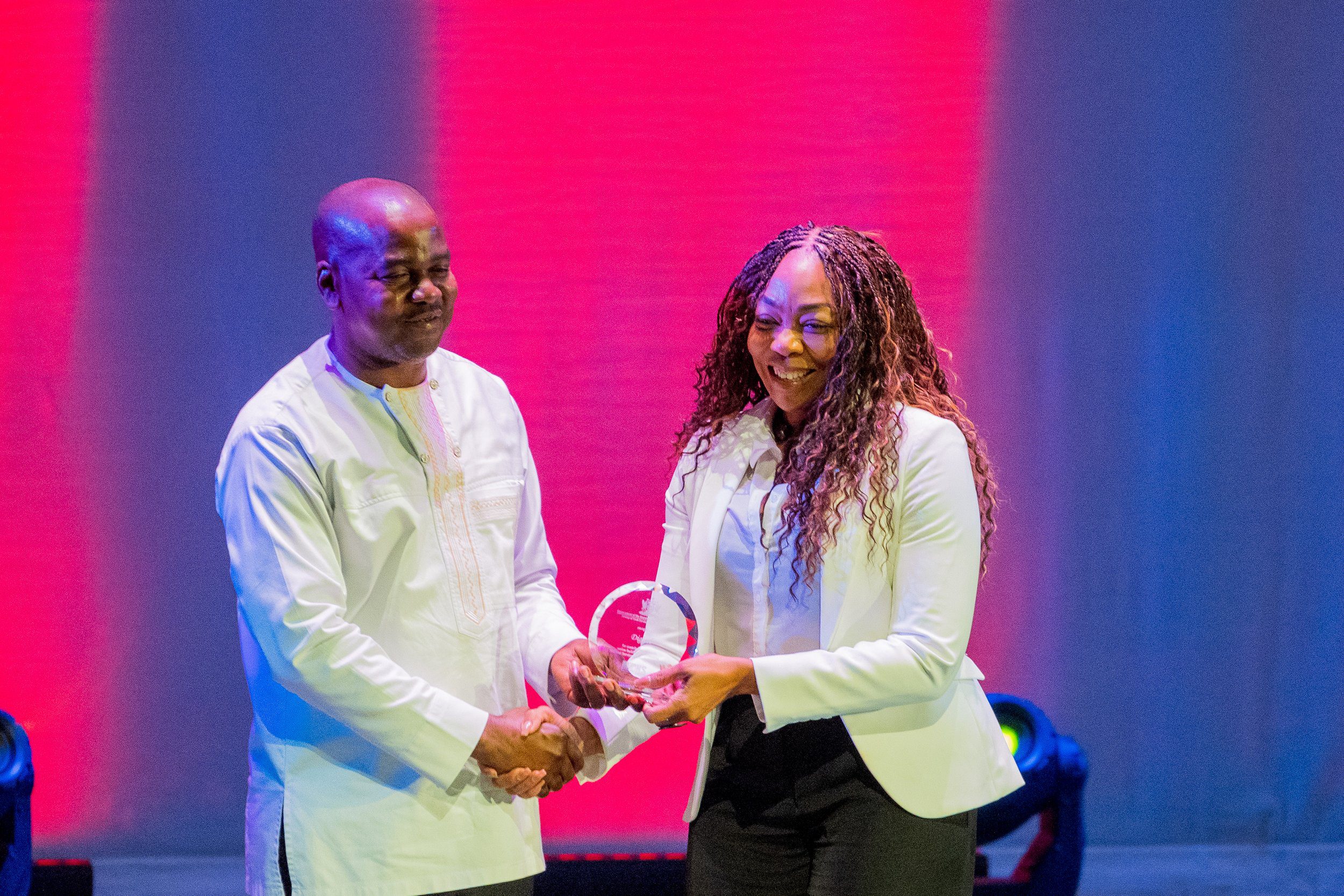 The Honourable Foster Cummings, Minister of Youth Development and National Service, presents Penny Gomez, CEO of the Digicel Foundation, with an honorary National Service Award at a MYDNS award ceremony held on 30 July at the Southern Academy for the Performing Arts.