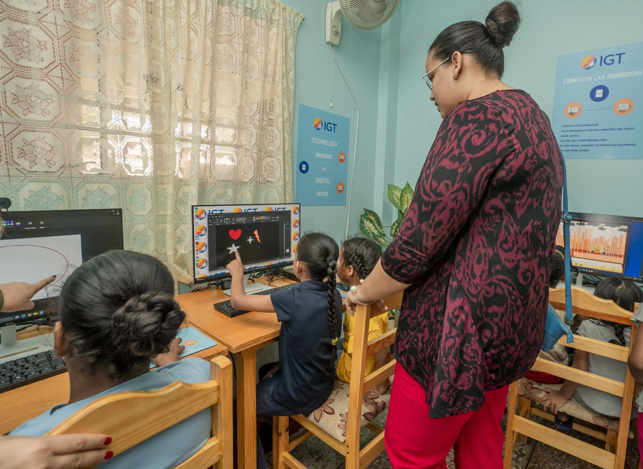 Marie-Louise Belmar Singh, Assistant Administrator at Amica House, supervises the girls while they explore educational software in one of the Home’s computer labs.