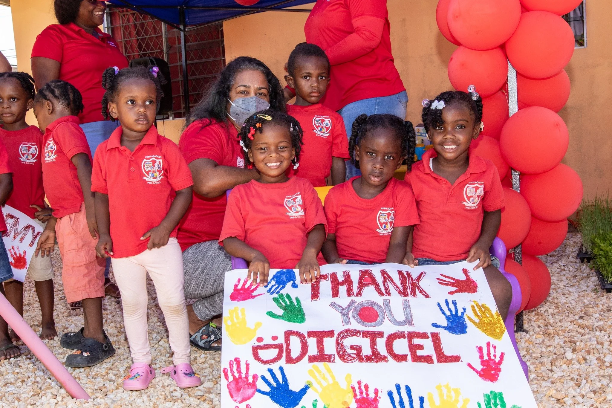 Showing their Appreciation! Kids from Eden’s Academy show off their “Thank You Digicel” artwork to the team of Digicel Retention Agents for enhancing their outdoor play area.