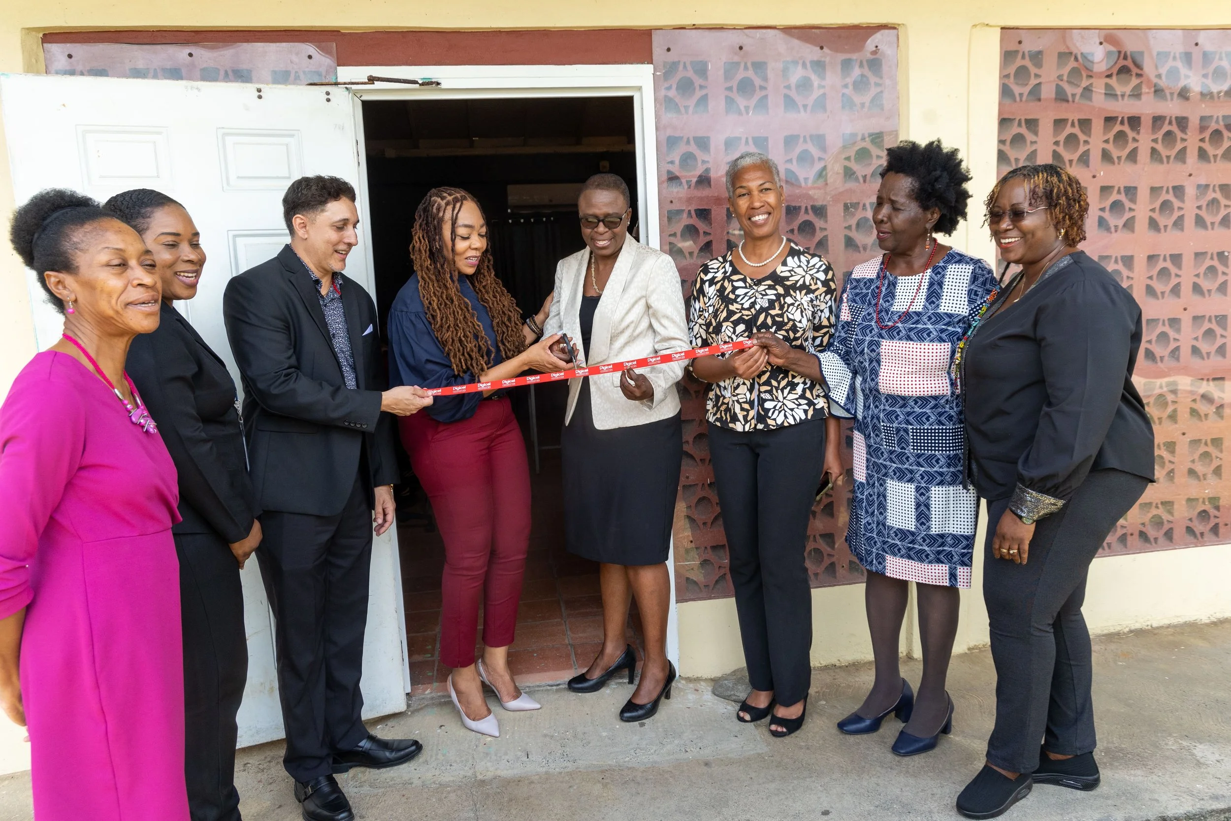 The Digicel Foundation and its innovation lab programme partners cut the ribbon on the new lab at Happy Haven School. From left to right: Gina Alleyne, School Supervisor 1, Division of Education Research and Technology; Kerchelle Elliott, Office of the Assistant Secretary, Division of Health, Wellness & Social Protection; Jason Matthews, General Manager, Digicel Plus; Penny Gomez, CEO, Digicel Foundation; Dianne Baker-Henry, Administrator, Division of Education Research and Technology; Stacey Ann Peterson, Principal, Happy Haven School; Dotsie Bacchus, Project Coordinator, Technical Vocational Centre; Georgina Peterkin, Board Director, Digicel Foundation.