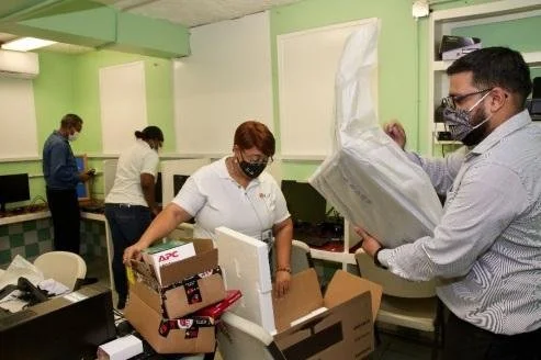 IGT Draw Coordinator Lead Leslie-Ann Baxam, and IGT Draw Coordinator Varun Bhageraty unpack new computers in preparation for installation at the Homework Centre located at Christ Child Convalescent Home. The IGT employees executed the entire installation much to the delight of the children at the home.
