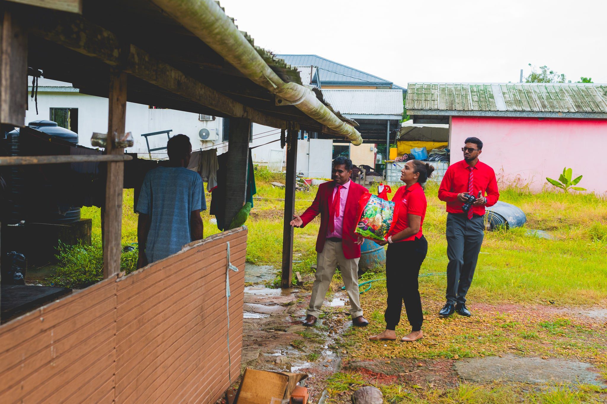Diana Mathura-Hobson, Project Officer at Digicel Foundation, and Alderman Gowtam Maharaj, Chairman of the Penal Debe Corporation, assisted by a PDRC employee, offloaded hampers for families in flood-affected areas.