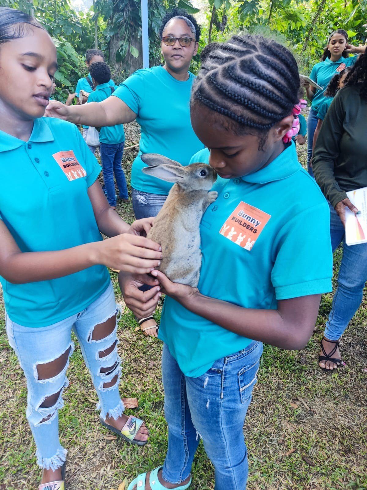Doing what they love best! These two bunny builders care for this little bunny as their training on the caring and rearing of rabbits come to an end.