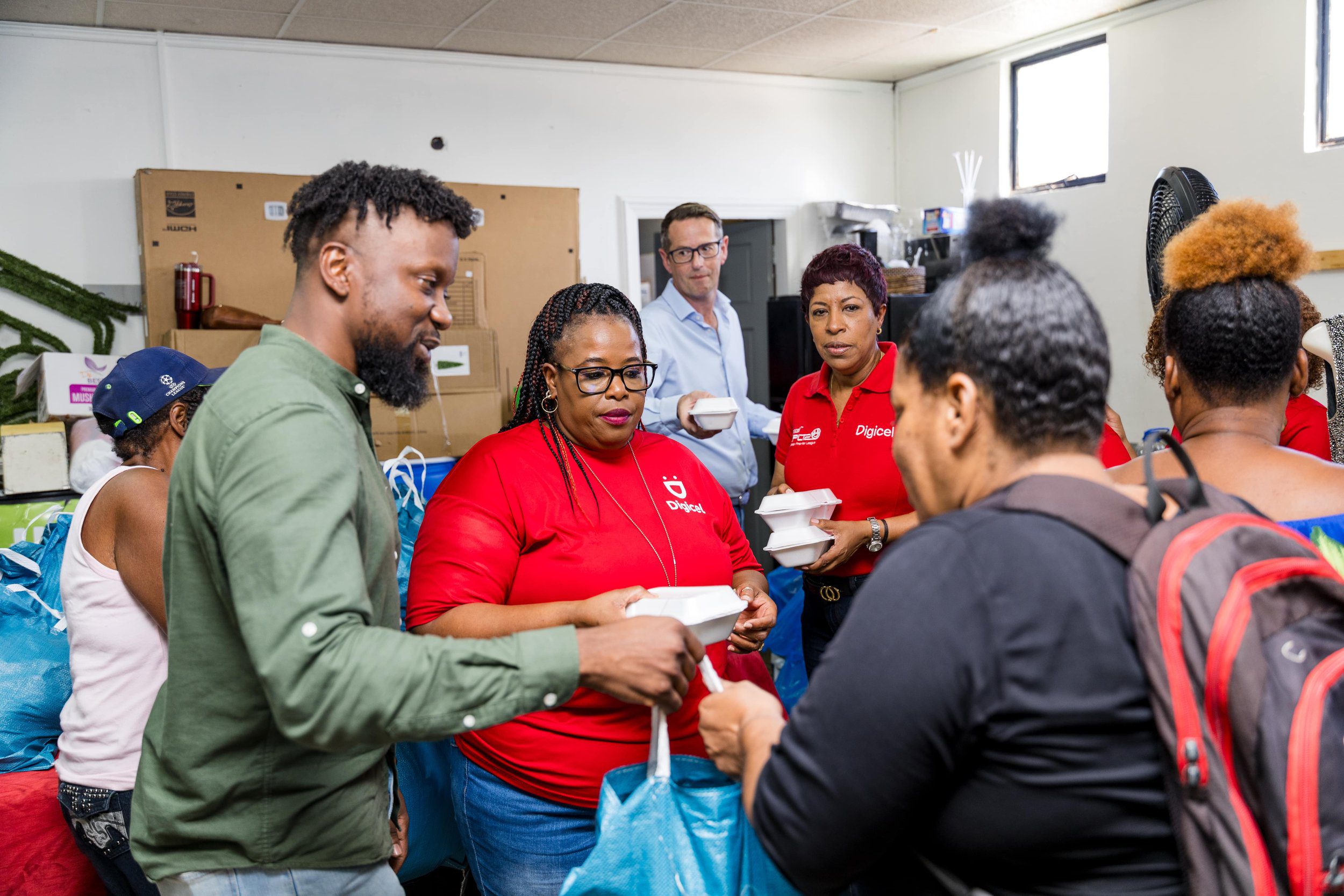 Diana Mathura-Hobson, Project Officer at Digicel Foundation, and Alderman Gowtam Maharaj, Chairman of the Penal Debe Corporation, assisted by a PDRC employee, offloaded hampers for families in flood-affected areas.