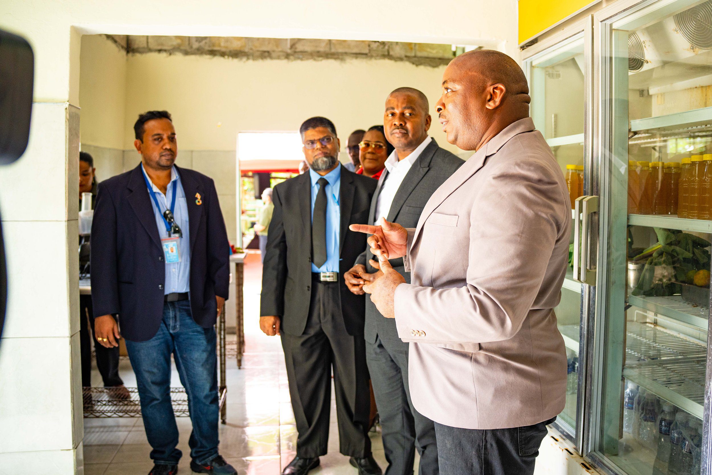 Randell Patterson, President of the Brazil Village Farmers Group, takes officials on a tour of the new Agro-Processing and Packaging Facility located at Brazil Lome Trace.