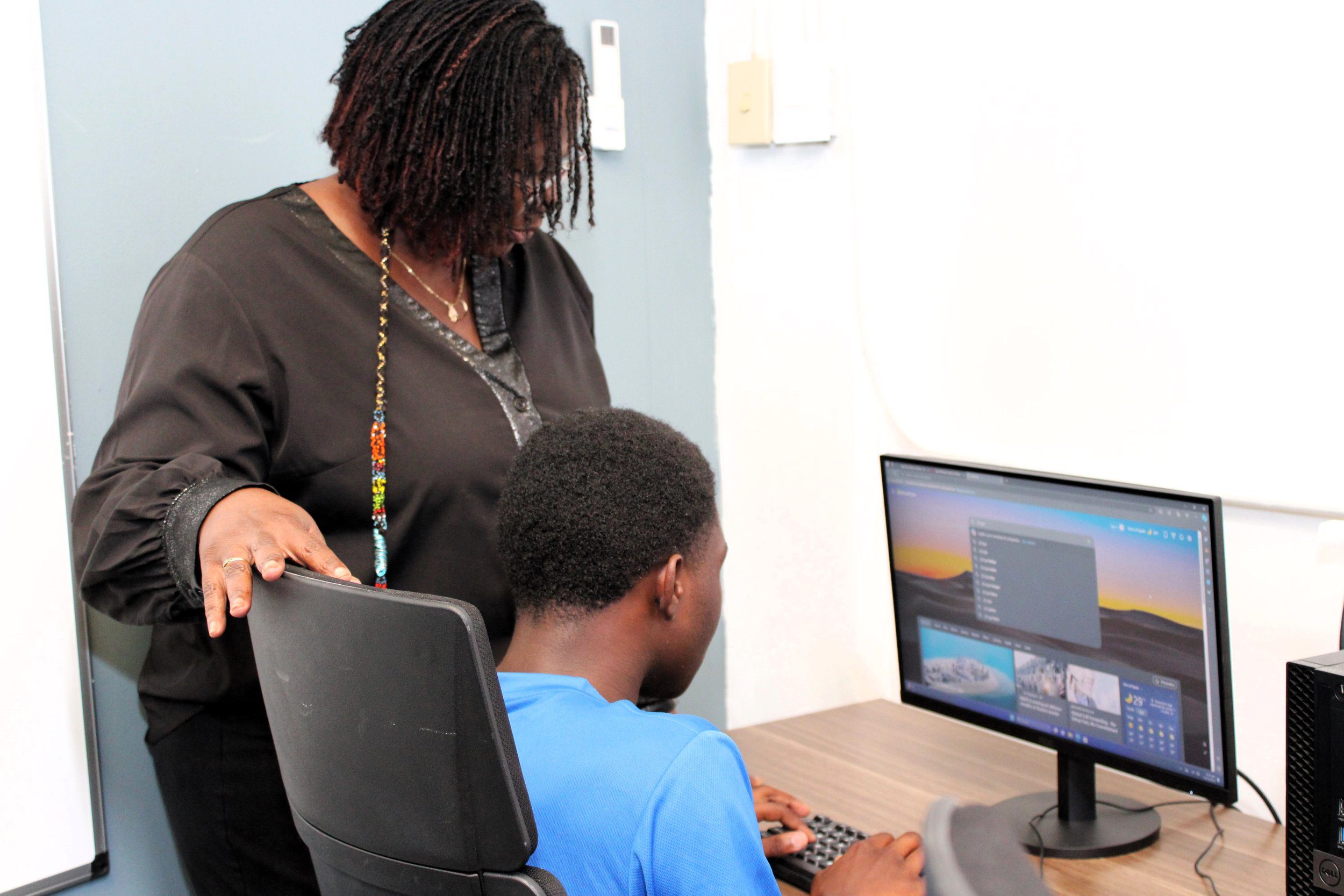Georgina Peterkin, Digicel Foundation Director, looks on as a community member tries out one of the new computers at the Katzenjammers Steel Orchestra TIE Centre in Black Rock, Tobago on Wednesday 13 March 2024.