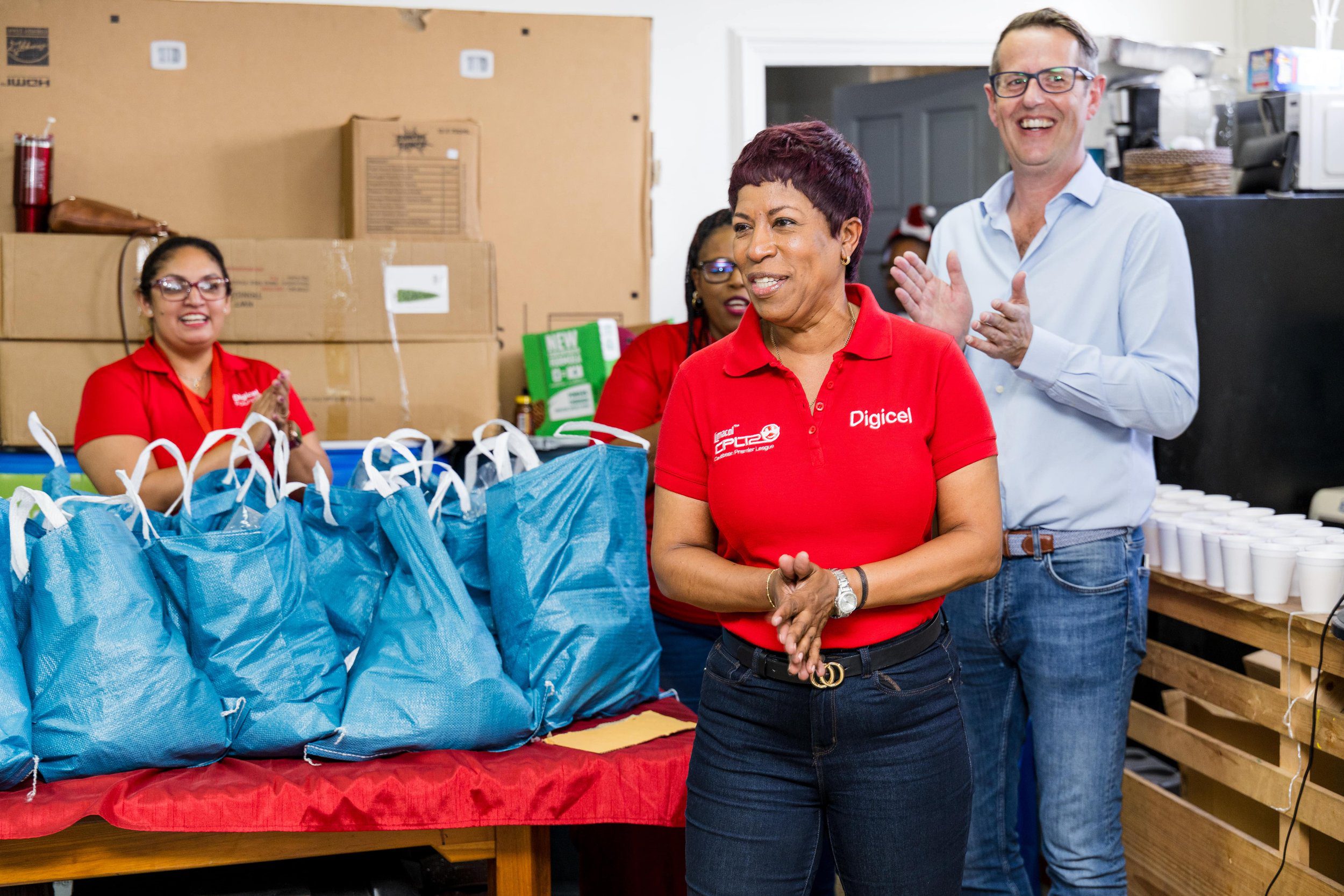 Diana Mathura-Hobson, Project Officer at Digicel Foundation, and Alderman Gowtam Maharaj, Chairman of the Penal Debe Corporation, assisted by a PDRC employee, offloaded hampers for families in flood-affected areas.