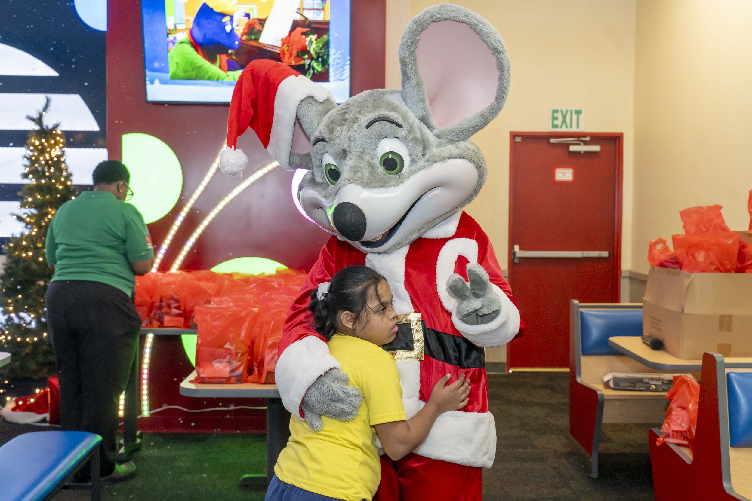 This little girl takes a break from the games to give Chuck E a special hug during the Digicel Foundation’s Children’s Christmas Party.