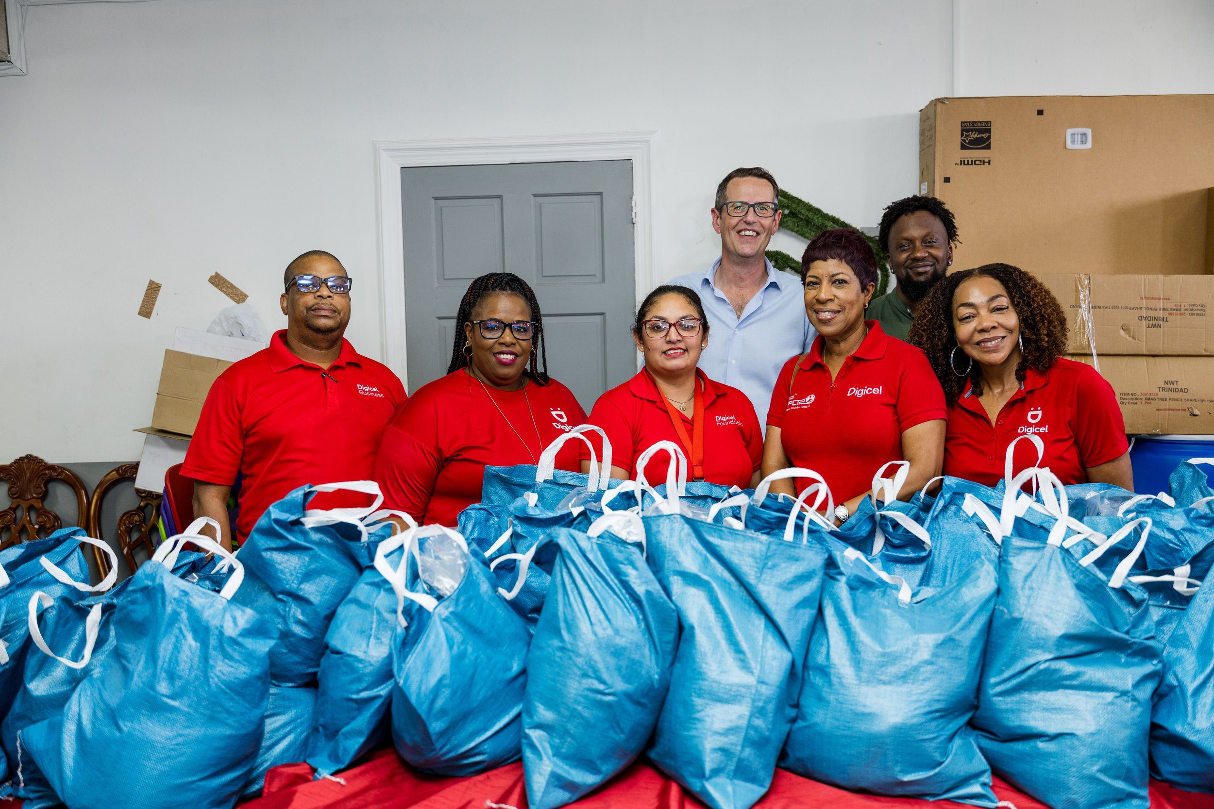 Diana Mathura-Hobson, Project Officer at Digicel Foundation, and Alderman Gowtam Maharaj, Chairman of the Penal Debe Corporation, assisted by a PDRC employee, offloaded hampers for families in flood-affected areas.