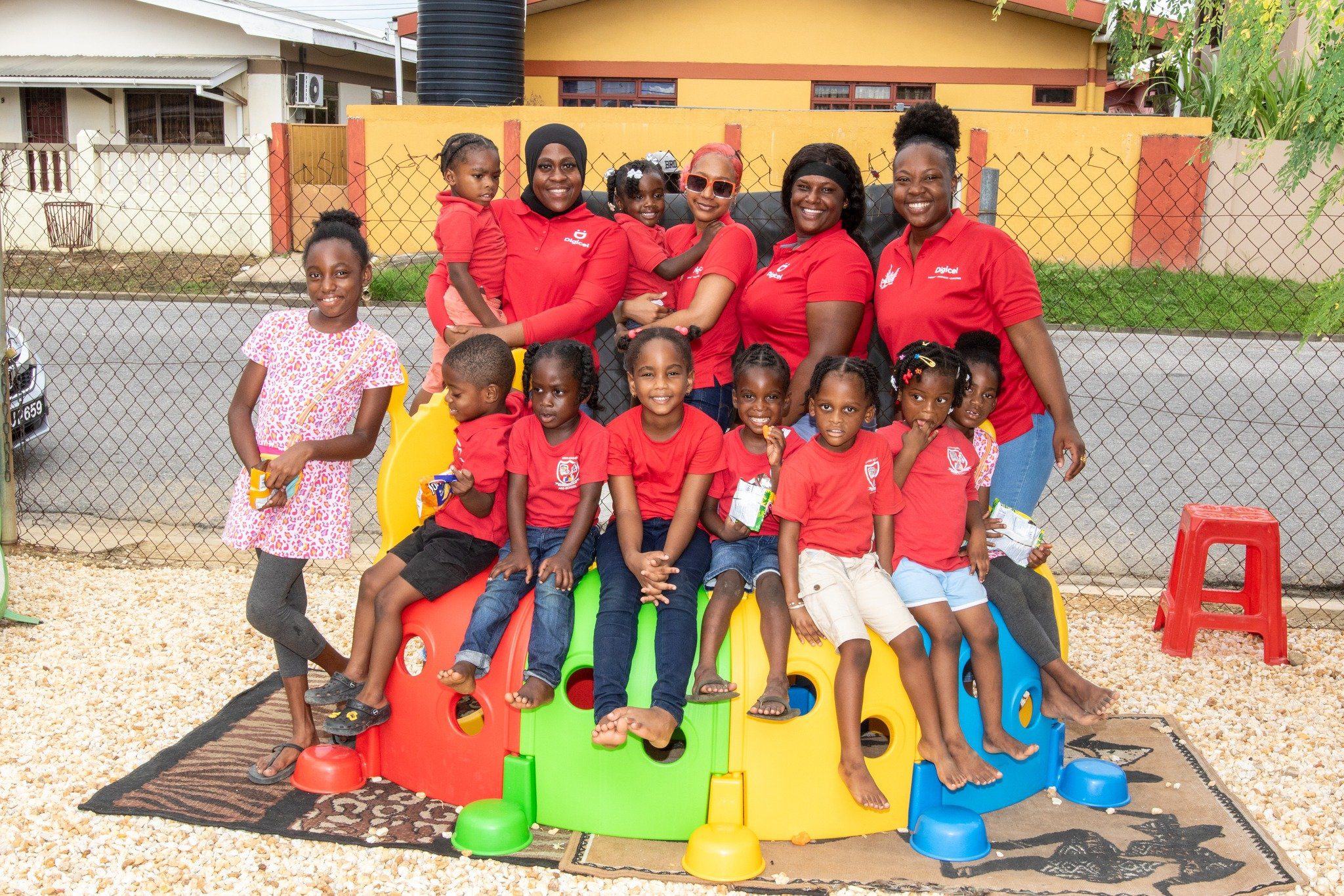 Bearing all smiles! Kids of Eden Academy preschool in Edinburgh 500 happily pose with a team of Digicel Retention Agents during their first playday at their newly enhanced outdoor play area courtesy the ‘Digi Christmas is D Bess’ Staff Initiative