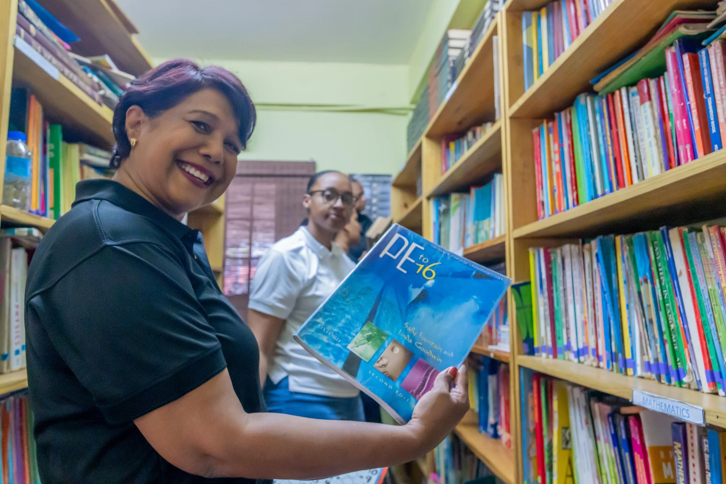 Marking the moment! Shavindra Tewarie-Singh, IGT People & Transformation Regional Senior Manager for the Caribbean, pauses from her volunteer work in the Amica House library to give a quick smile.