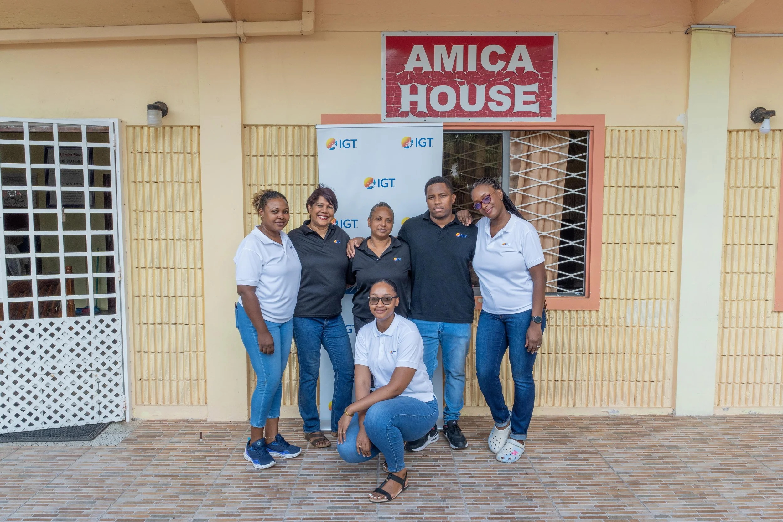 From left) Rowen Marshall, IGT Call Center Associate; Shavindra Tewarie-Singh, IGT People & Transformation Regional Senior Manager for the Caribbean; Devika Harricharan, IGT Relationship Strategy Officer; Deshawn Bruce, IGT Repair Technician; Cherisse Charles-Bradshaw, IGT Chief Accountant; and Chelsea Alleyne, IGT’s Administrative Assistant, all pose together to commemorate IGT’s Global Giving Month 2024 at the Amica House children’s home.