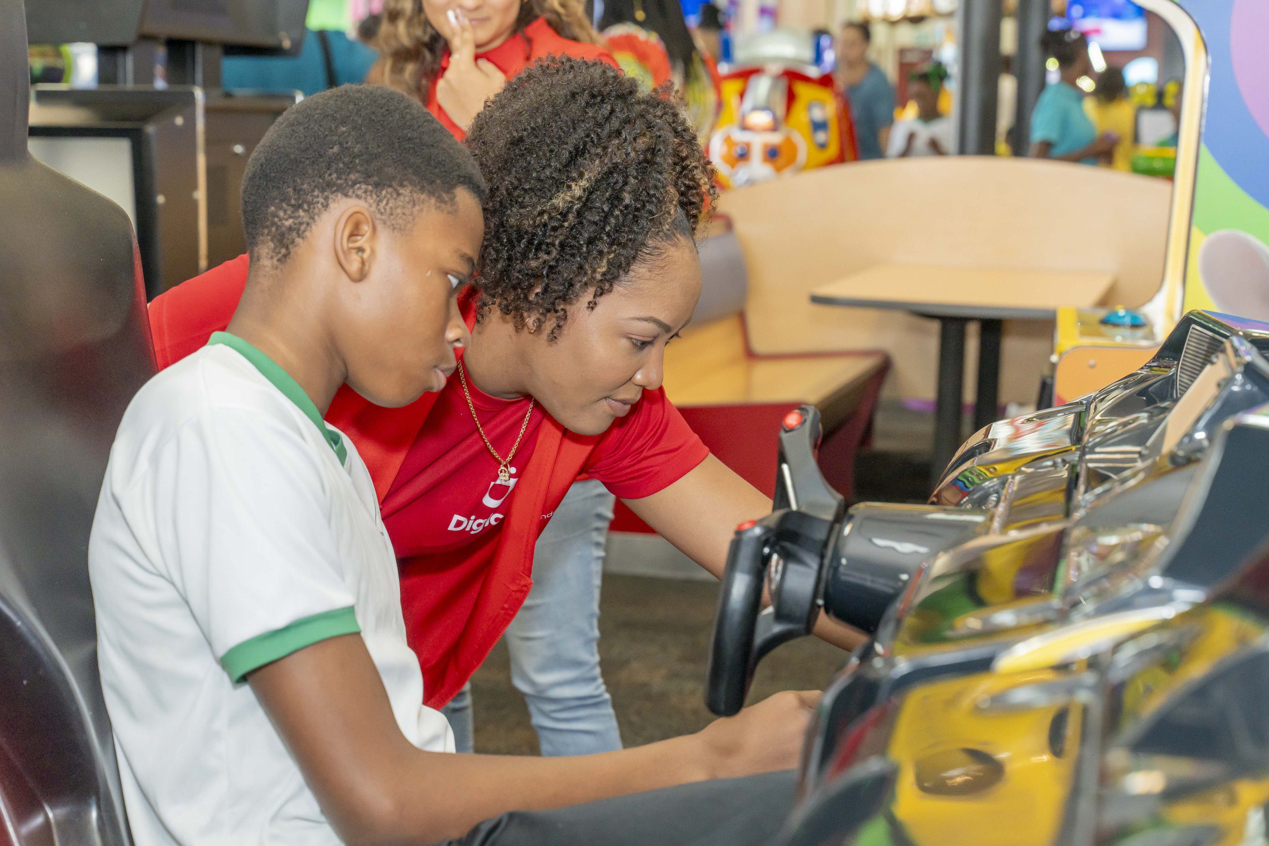 Digicel volunteer Lou-Anne Joseph, Training Executive - Digicel Learning and Development, helps this youngster get the game going.